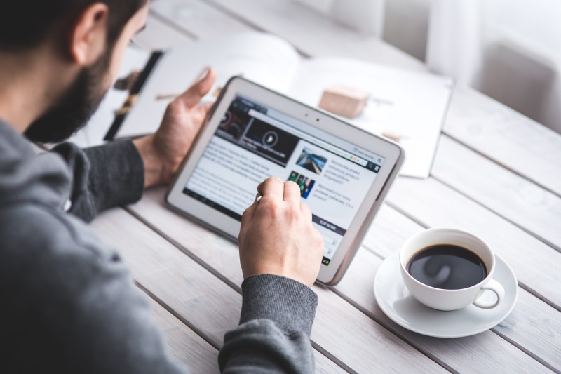 touching, working, mug, coffee, communication, connection, hand, over the shoulder view, holding, news, one person, man, browser, table, adult, indoors