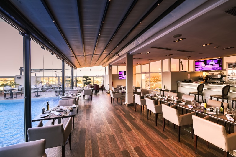 gray, trading floor, tables, room, modern, indoors, person, lighting equipment, setting, chairs, table, business, restaurant, illuminated, architectural column
