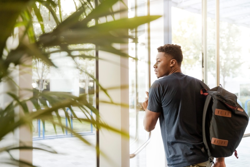 office, architecture, one person, sunlight, foliage, bag, work, sales person, leisure activity, waist up, outdoors, door, young men, glass, sales pro, three quarter length