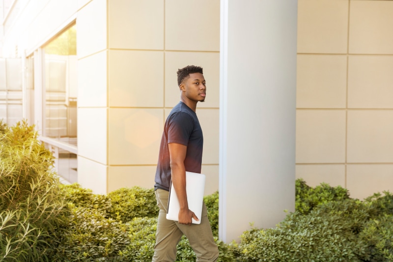 lifestyles, salesman, student, carrying, architecture, folder, standing, profile view, men, young adult, contemplation, casual clothing, real sale, towards