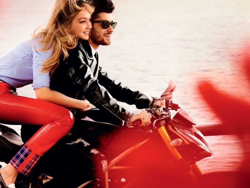 mode of transportation, celebrities, sitting, gigi hadid, leisure activity, young women, real people, zayn malik, outdoors, young men, beautiful woman