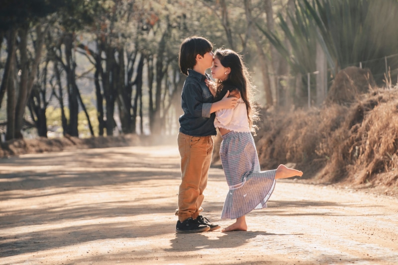 tree, leisure activity, full length, forehead, nature, daughter, togetherness, women, emotion, adult, boy, daytime, casual clothing, people, love, sunlight
