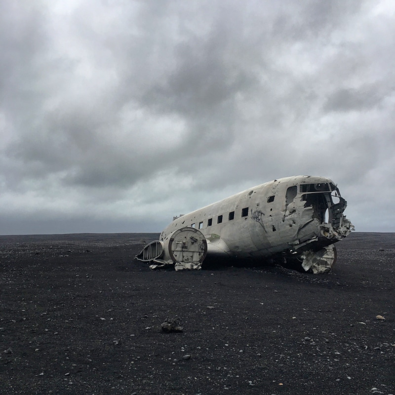 mode of transportation, wrecked, daytime, air vehicle, gray, gravel, ruined, iceland, sky, deterioration, land, travel, nature, overcast, no people, beach