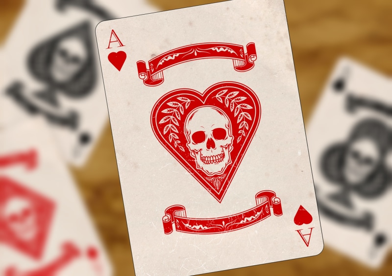male likeness, playing, pattern, creativity, text, human representation, skull and crossbones, ace, celebration, playing cards, heart, focus on foreground