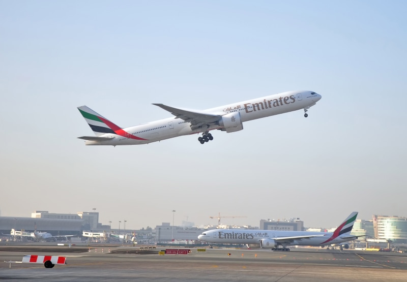 cityscape, 777, flying, UAE, passenger, outdoors, white, twin-engine, airplane, the sky, city, no people, transportation, day, sky, jet, bokeh