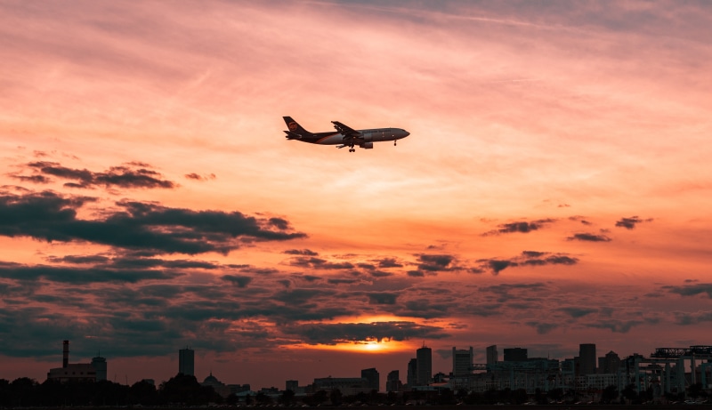 outdoors, clouds, sunset, sunlight, sunrise - Dawn, air, cloud - Sky, landing - Touching Down, white, mid-air, sun, built structure, aerial View, silhouette