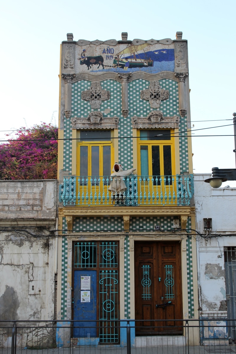 the past, clear sky, balcony, building exterior, travel destinations, flower, no people, city, built structure, nature, concrete, communication, low angle view