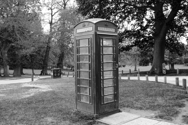 phone box, monochrome, growth, no people, architecture, field, natural light, telephone booth, connection, pay phone, park - man made space, day, nature