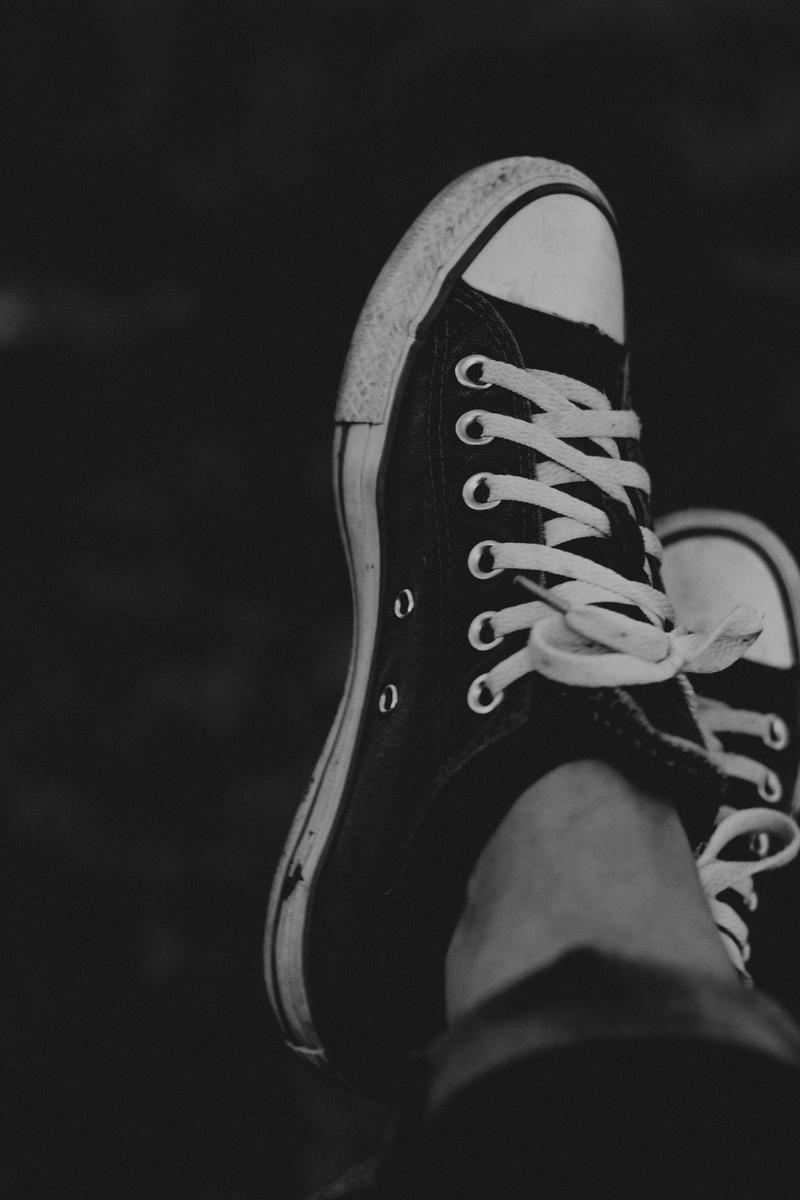 sports equipment, body part, shoelace, leisure activity, 5K, shoe, legs crossed at ankle, day, black and white, dirty sneaker, personal perspective, shoe lace