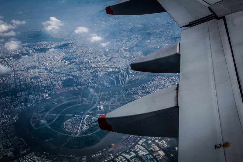 above, airplane, day, engine, mid-air, architecture, winter, vietnam, cityscape, no people, transportation, building exterior, person, flight, aircraft