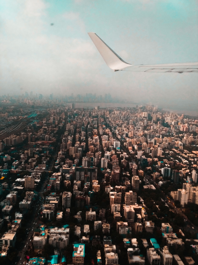 built structure, skyscraper, outdoors, clouds, cityscape, transportation system, buildings, nature, city, roads, aircraft wing, travel destinations, office building exterior
