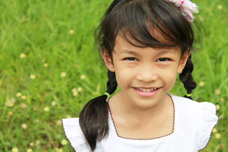 flowering grass, the lawn, neckline, one Person, girl, color Image, outdoor, beautiful smile, toothy smile, cap, focus on foreground, children only, sleeved