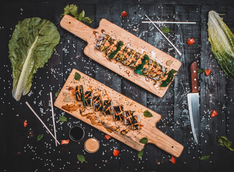 no people, food and drink, ingredient, sushi, wood plate, vegetarian food, restaurant, indoors, directly above, boards, roll, platter, preparation, kitchen knife