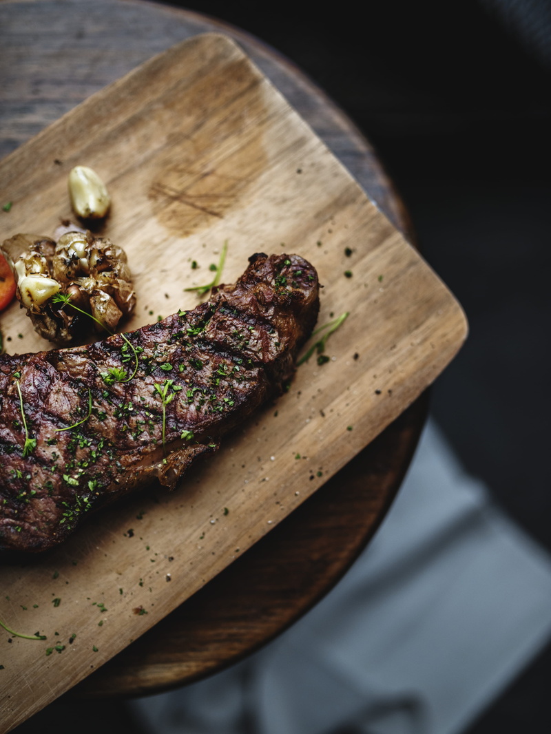 cutting board, high angle view, cooked, red meat, wooden, indoors, table, from above, 4K, brown, focus on foreground, garlic, roasted, grilled, barbecue