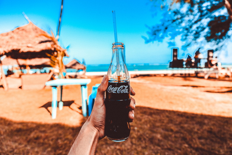 focus on foreground, alcohol, landscape, cola, person, container, water, tropical, trees, coca, drink, seascape, human body part, 5K, sand, day, daylight
