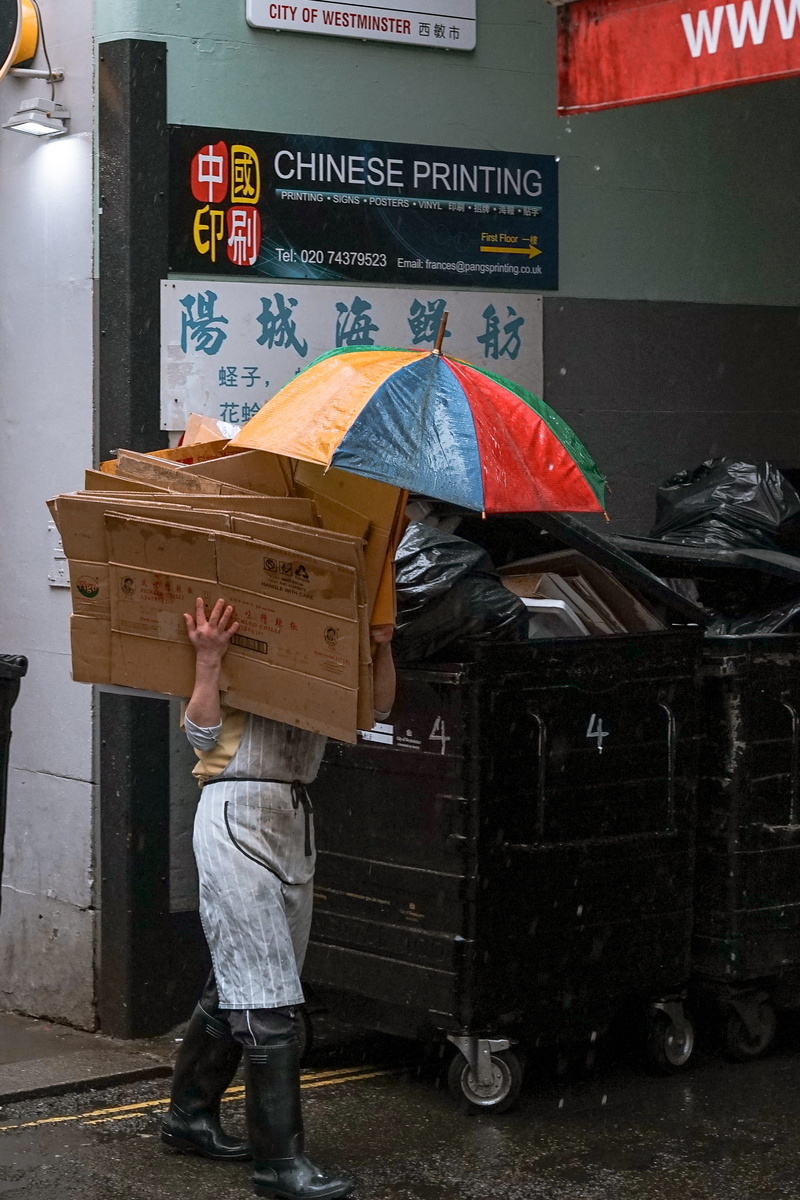 2K, container, standing, chinatown gate, package delivery, day, city, mode of transportation, human, obscured face, black, one person, women, shorts, box