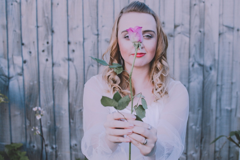 lipstick, outdoors, one person, pink, woman, fence, blonde, hairstyle, standing, looking at camera, girl, rustic, front view, 5K, garden, plant, wood