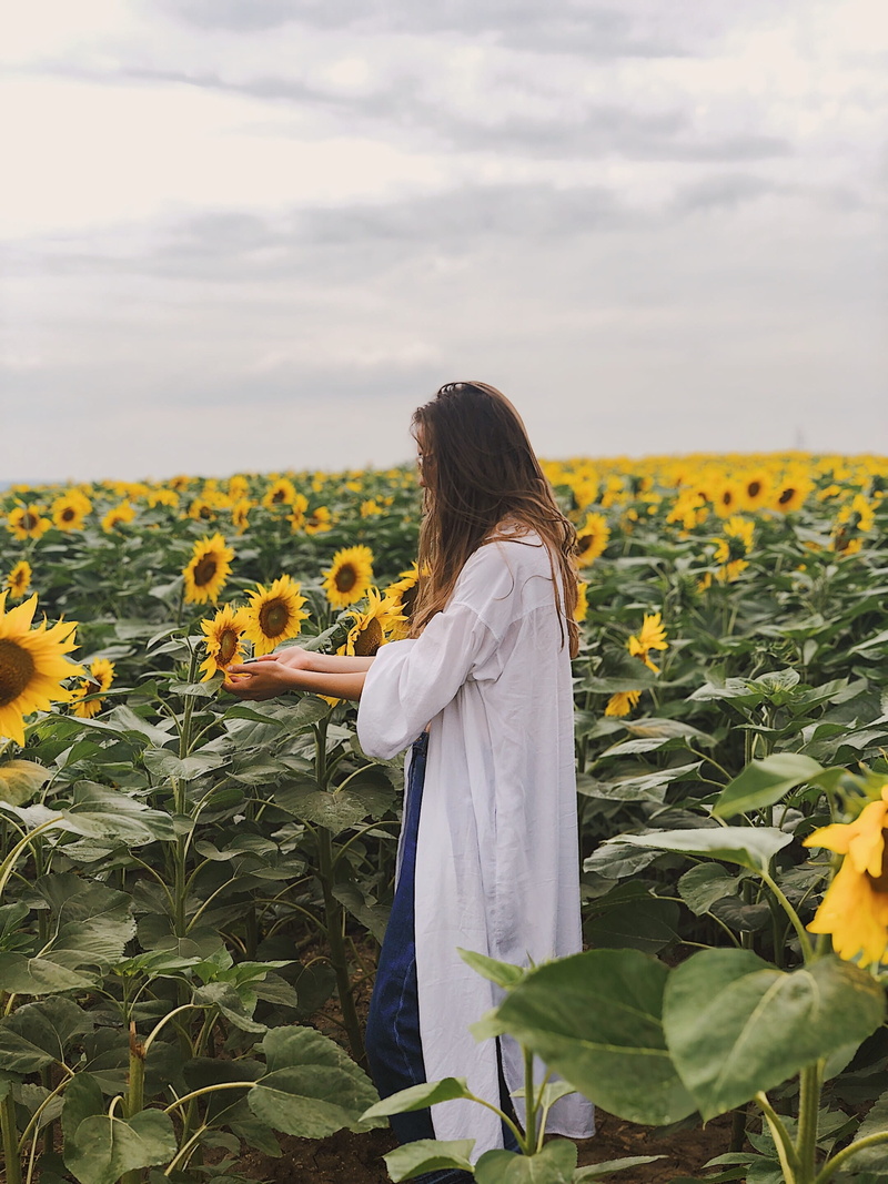 hair, clouds, sunflower, leisure activity, outdoors, flower head, agriculture, beauty in nature, one person, people, woman, plant, weird, summer, standing