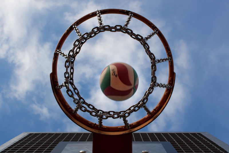 low angle view, basketball hoop, outdoors, blue sky, ball, geometric shape, hoop, built structure, architecture, lamp post, sports, art, day, team sport