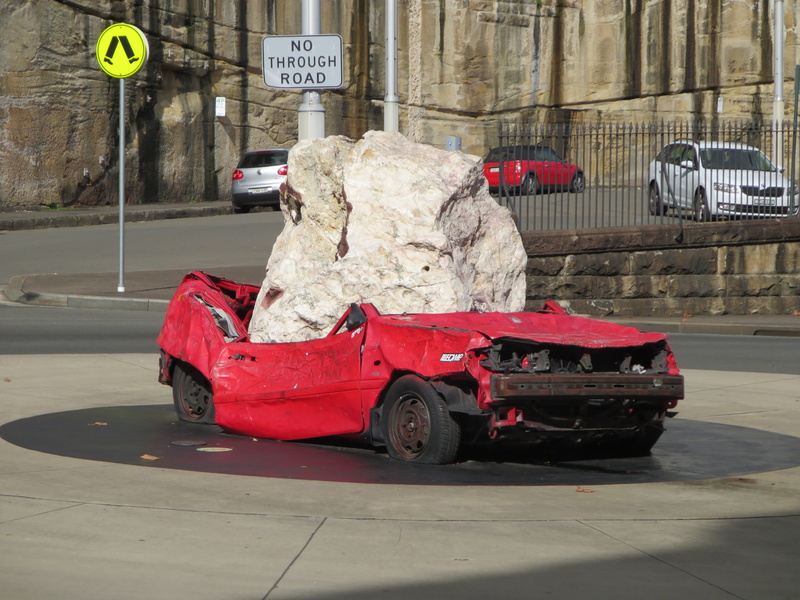 travel, red, land vehicle, road, built structure, gray, boulder, wreck, city, motor vehicle, concrete, day, sign, danger, outdoors, communication, incidental people
