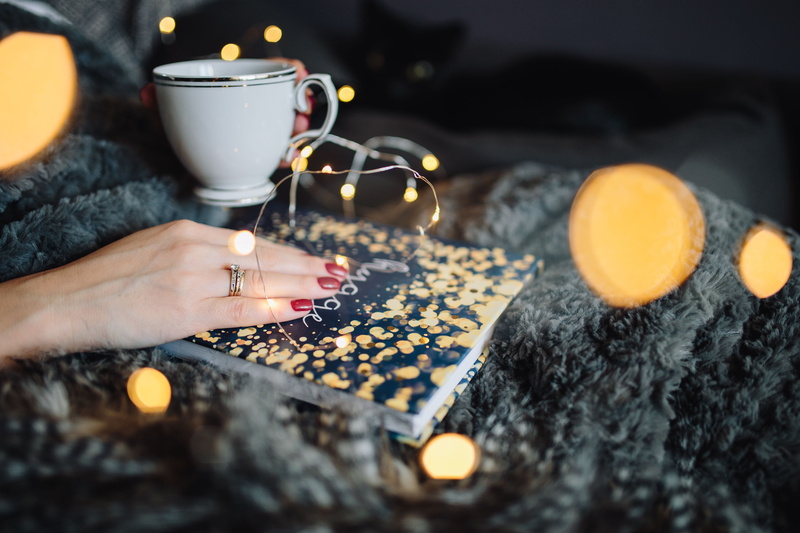 indoors, cup, drinking, human limb, young, femine, drink, burning, reading, tea light, fairy lights, illuminated, book, christmas, Hygge, adult, cookie