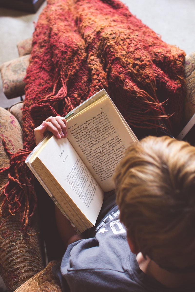 sitting, hair, publication, adult, blanket, education, high angle view, man, hairstyle, real people, reading, one person, holding, casual clothing, male