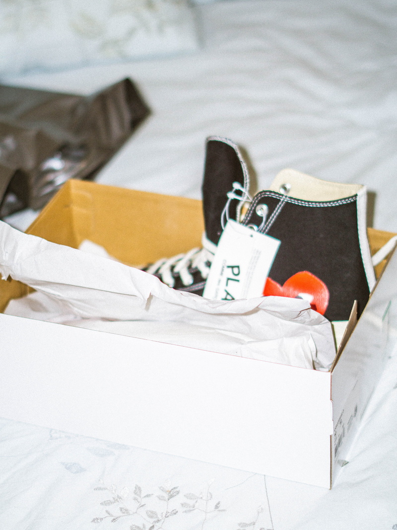 white color, indoors, bed, sheet, shoe, comme, des, linen, home interior, clothing, black, unpaired, no people, textile, cdg, paper, top, still life, flash