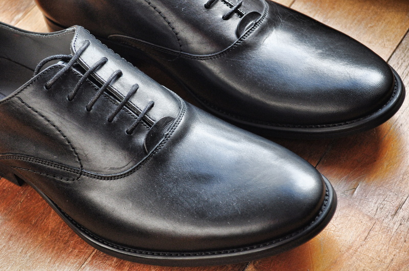dress shoe, shoe laces, table, black color, personal accessory, dress, leather, wooden, brown, black, flooring, menswear, two objects, indoors, lace - fastener