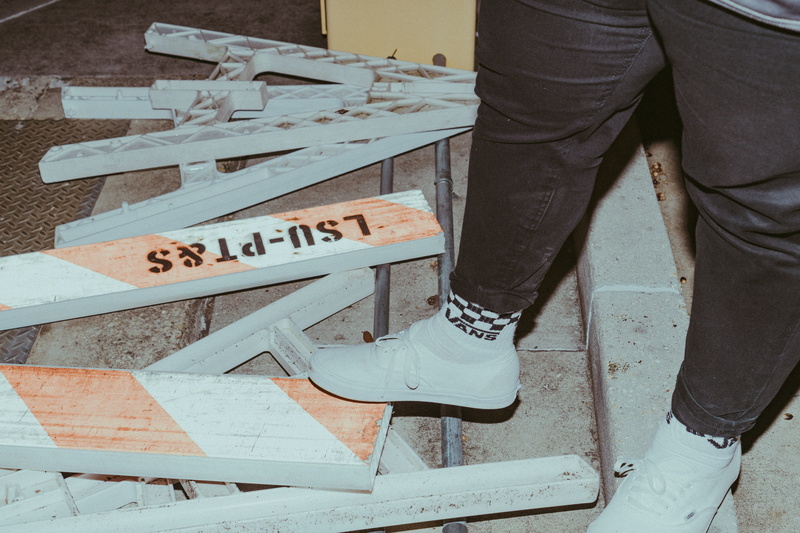 jeans, sneaker, text, one person, pose, construction, running shoe, sign, white, shoe, person, low section, pants, real people, human leg, human, body part