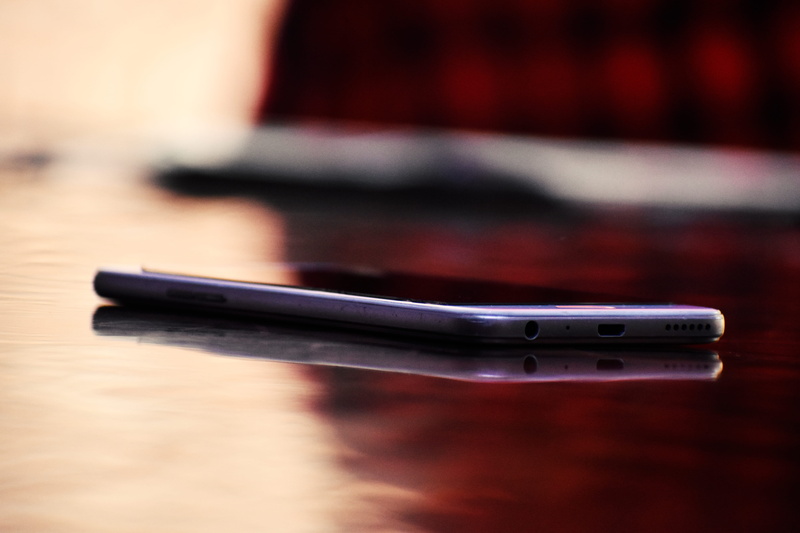 blur, digital device, focus on foreground, office, mobile phone, light, equipment, no people, table, writing instrument, wireless technology, close-up