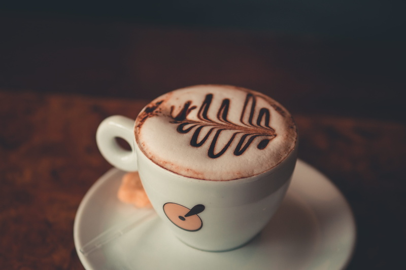 coffee drink, frothy drink, creativity, dark, non-alcoholic beverage, wooden, breakfast, focus on foreground, saucer, cappuccino, food and drink, caffeine