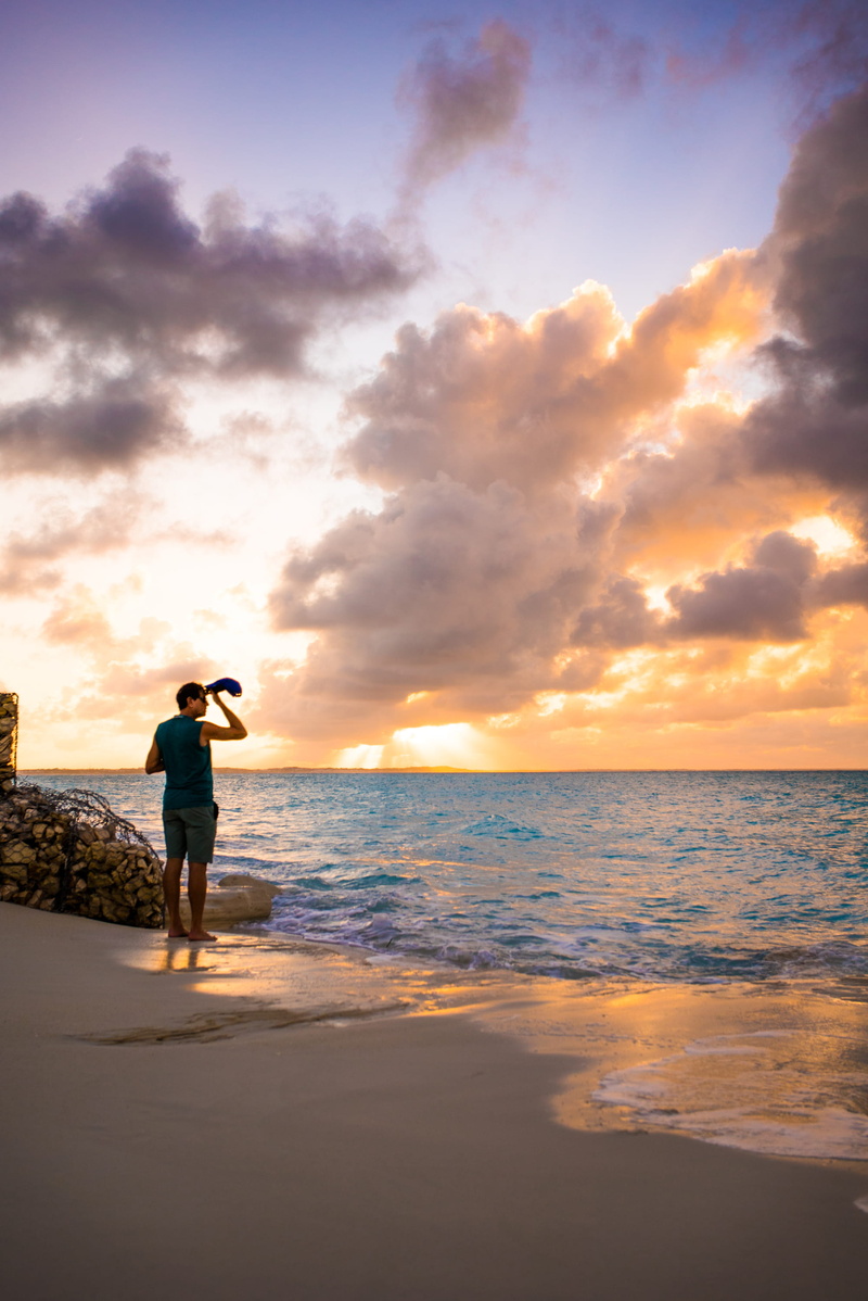 horizon over water, standing, real people, water, beauty in nature, one person, full length, sunset, people, cloud - sky, outdoors, lifestyles, photography themes