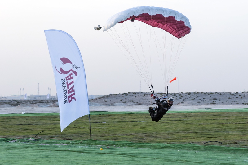 outdoors, sky, nature, sport, finish, motion, paragliding, water, competition, extreme sports, flying, landing, qatar, transportation, land, full length