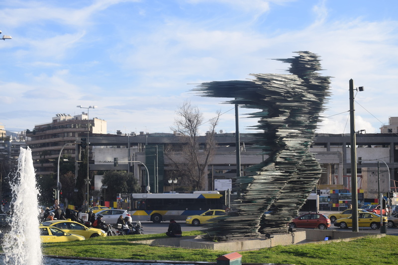 grass, mode of transportation, fountain, motor vehicle, city, street, cloud - sky, outdoors, building exterior, water, taxi, buildings, cursor, day, built structure