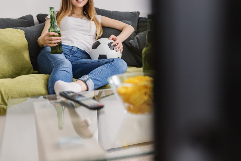 holding, domestic life, tv, drink, adult, lifestyles, refreshment, young, football, sport, sitting, jeans, drinking, casual clothing, excited, one person
