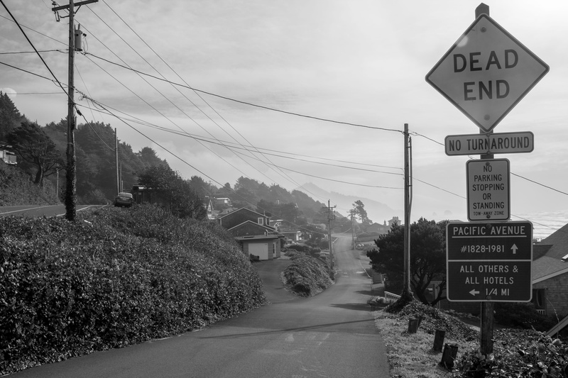 western script, asphalt, street, signage, sign, cable, building, communication, symbol, way, sky, dirt road, dead, end, information, no people, guidance