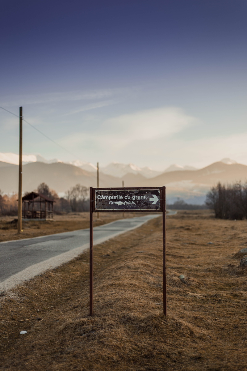 nature, slope, transportation, highway, sky, spire, dirt road, way, black, road sign, mountain, building, tranquility, goal post, tarmac, sport, vehicle