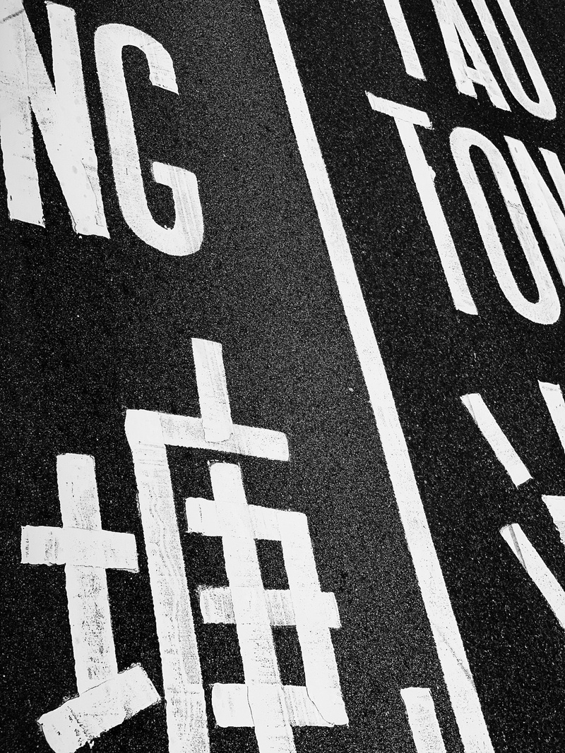 full frame, handrail, corridor, banister, road marking, day, communication, sign, street, city, track and field, road, alphabet, marking, text, brick, white color