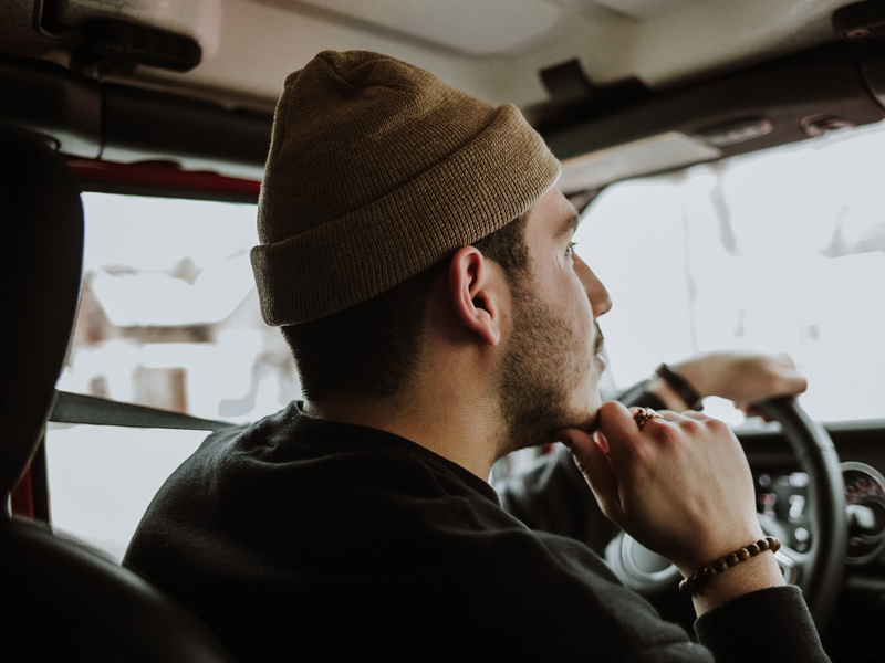furniture, transportation, lifestyles, one person, brass section, car interior, chin, real people, hat, cap, public transportation, travel, car, gauge