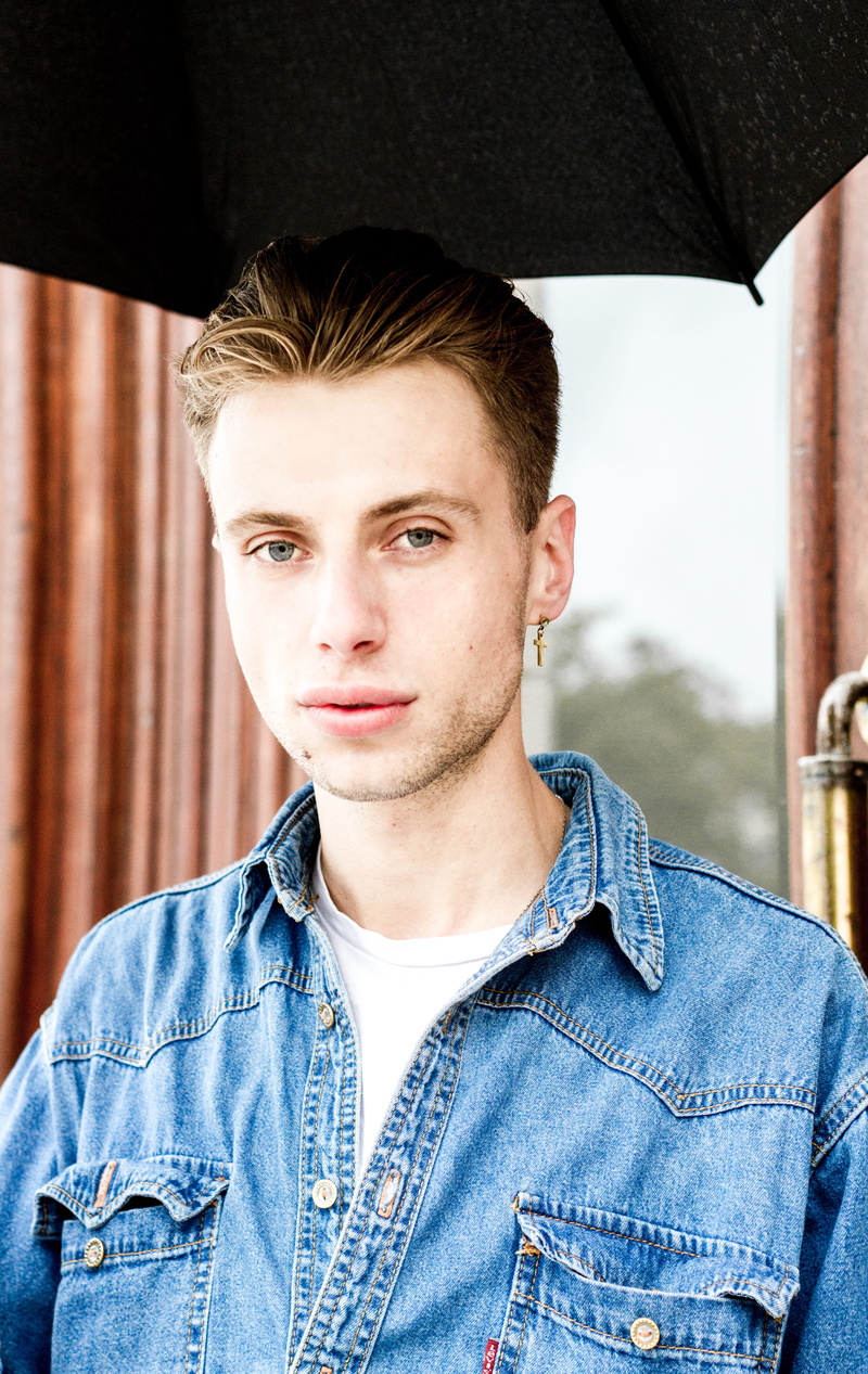 plumbing, musical instrument, jacket, leisure activity, person, textile, graduation, young adult, window, day, blue, jeans, face, front view, young men