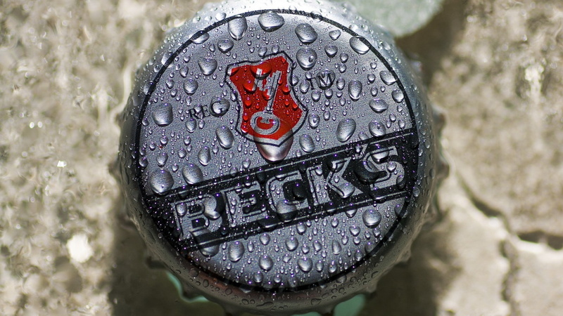 drop, text, western script, raindrop, becks, water, day, 1080P, rainy season, directly above, communication, outdoors, metal, close-up, no people, focus on foreground