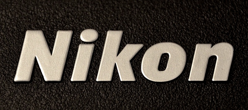 western script, form of communication, nikon, carpet - decor, black color, mat, road, number, textured, indoors, 2K, capital letter, sign, communication