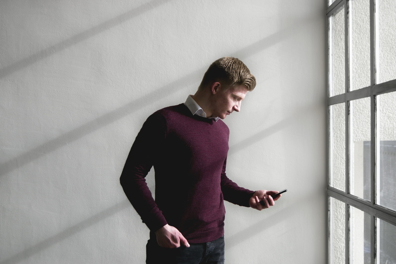 architecture, wall - building feature, casual clothing, holding, portrait, standing, portable information device, looking, man, technology, smartphone