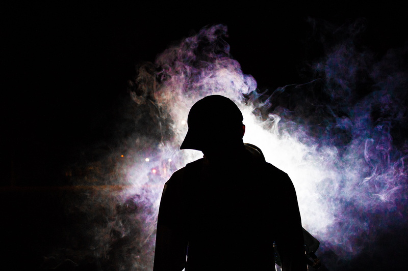photography, person, darkness, smoke, male, cap, guy, smoky, smoke - physical structure, event, man, black background, one person, purple, misty, mist