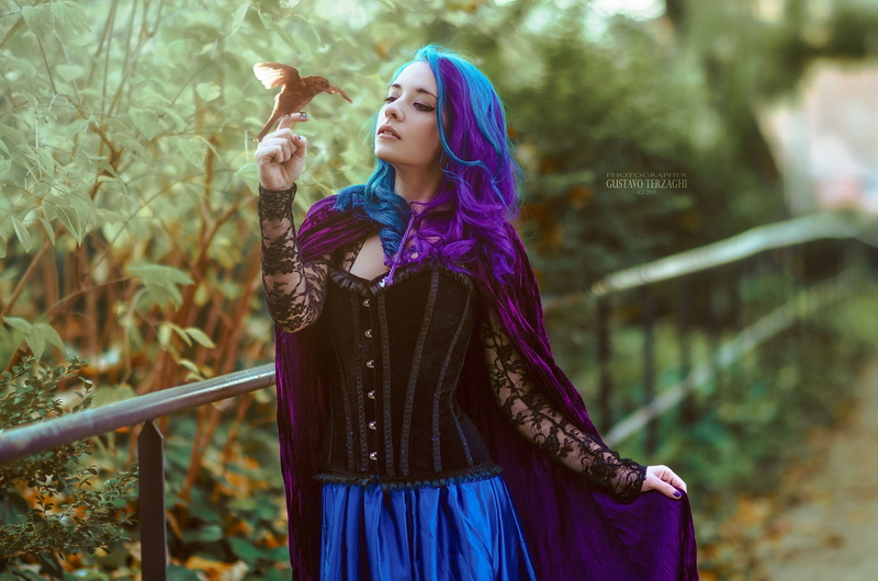 purple hair, birds, Gustavo Terzaghi, pierced nose, skirt, multicolored hair, black, corset, cape, long hair, green, make up, blue hair, wavy hair, blue clothing