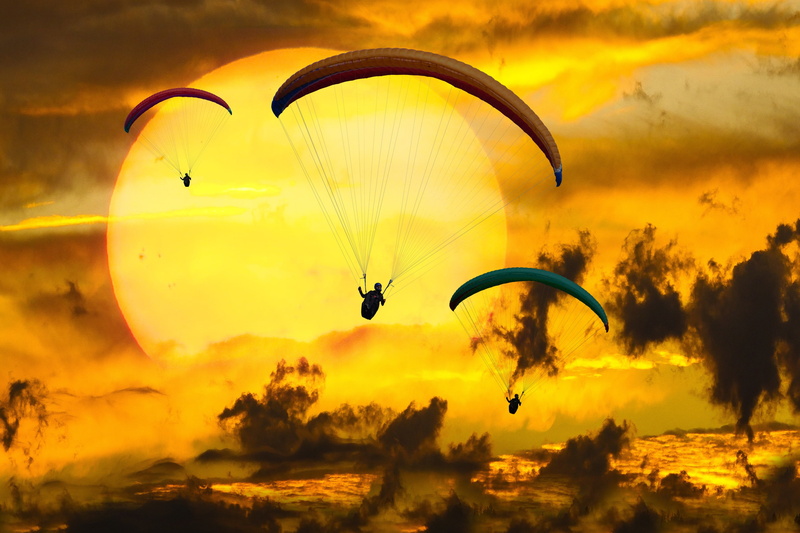 beauty in nature, extreme sports, flying, paraglider, joy, 2K, parachute, outdoors, silhouette, unrecognizable person, sun, mid-air, adventure, exhilaration