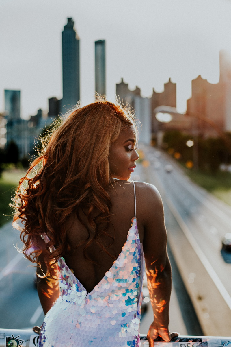 beautiful woman, focus on foreground, fashion, urban, built structure, outdoors, building, sequinned, sequin, bokeh, leisure activity, model, one person