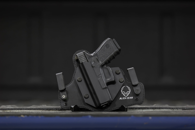 black background, Holster, still life, ccw, gun, technology, metal, pistol holster, owb holster, firearm, selective focus, gunrights, no people, focus on foreground