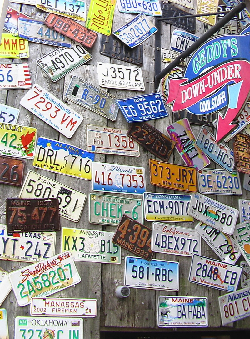 large group of objects, representation, multi colored, bar harbor, indoors, pattern, day, abundance, communication, in a row, text, license plates, backgrounds