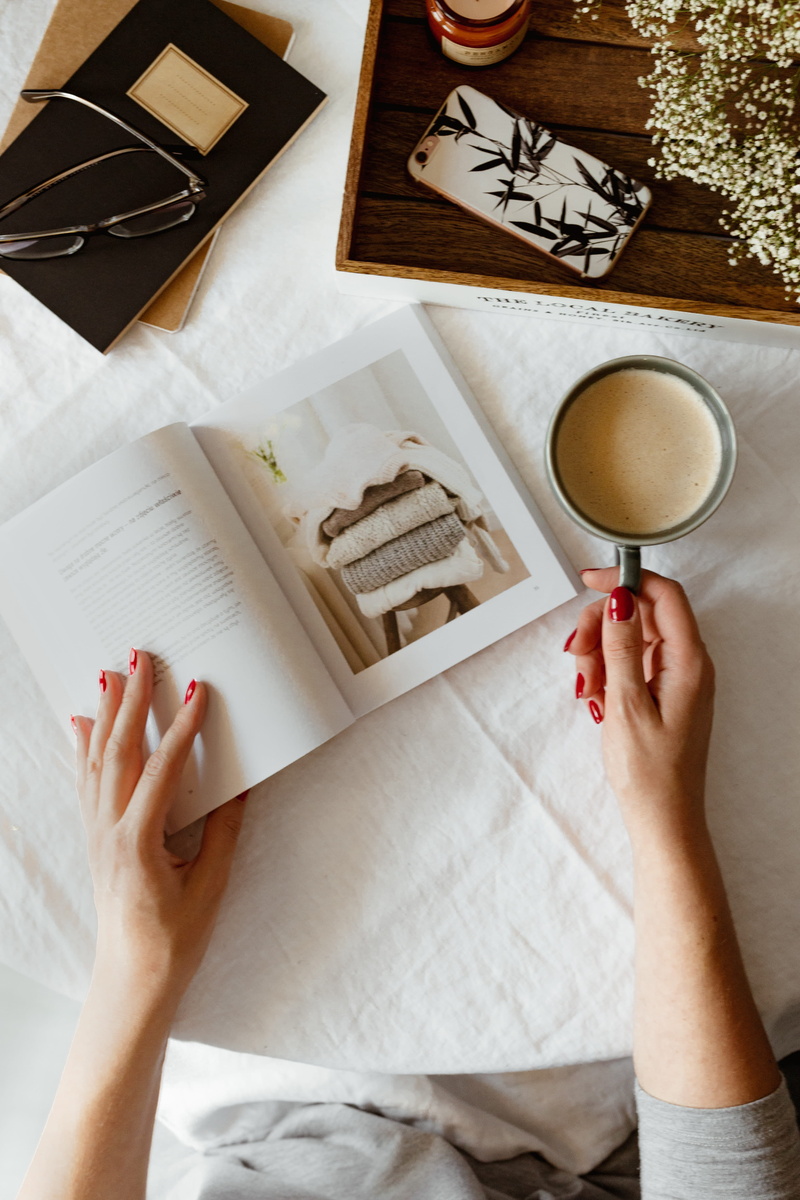 one person, relaxing, late, drink, reading, paper, lifestyles, coffee, kitchen utensil, women, cappucino, book, hands, directly above, top view, human body part